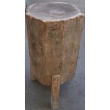 A large primitive made trunk-form chopping block, on three square supports,