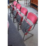 A bank of four red upholstered folding theatre seats, on black metal tubular frames,