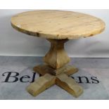 A modern pine circular dining table, on tapering column and X-frame base,