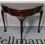 A George III style mahogany bowfront foldover card table, on acanthus turned supports,