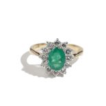 A gold, emerald and diamond oval cluster ring,