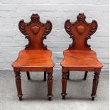 A pair of Regency mahogany shield back hall chairs, on tapering reeded supports,