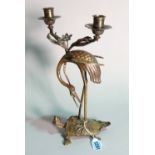 A Chinese bronze twin branch candelabra, modelled as a heron on a beast, 35cm high.
