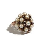 A gold, cultured pearl and garnet cluster ring, in a raised design, detailed 14 K, ring size O,