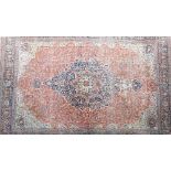 A large antique Kashan carpet, Persian, the madder field with a bold dark indigo,
