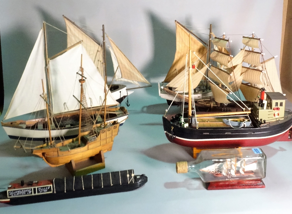 A group of eight modern wooden models of boats and sailing ships,