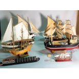 A group of eight modern wooden models of boats and sailing ships,