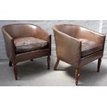 A pair of Regency style leather upholstered tub back armchairs, on turned supports,