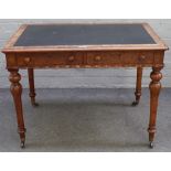 A Victorian figured walnut two drawer writing desk, with wavy frieze and turned supports,