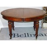 A late Victorian mahogany extending dining table, on reeded tapering supports,