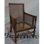 A 19th century oak framed bergere chair on bobbin turned supports, 58cm wide x 96cm high.
