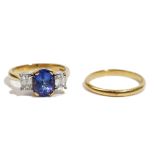 An 18ct gold, tanzanite and diamond three stone ring, the central oval cut tanzanite,