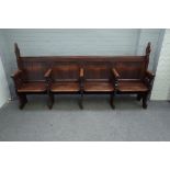 An oak Gothic Revival four seat church pew with pierced trefoil decoration, 240cm wide x 116cm high.