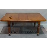 A Victorian mahogany extending dining table, on reeded supports, with one extra leaf,