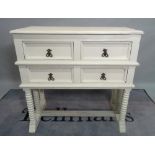 An 18th century style white painted side table, with four small drawers on bobbin turned supports,