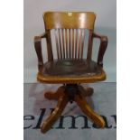 An early 20th century stained beech swivel office open armchair, 53cm wide x 83cm high.