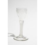 An engraved opaque twist wine glass, circa 1765, the ovoid bowl engraved with a sunflower,