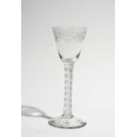 An engraved wine glass, circa 1750, the rounded funnel bowl engraved with trailing flowers,