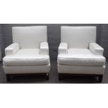 A pair of hardwood framed square back low armchairs with white upholstery on square tapering