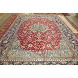 A Kasham carpet, Persian, the madder field with a dark indigo medallion, pale indigo spandrels,