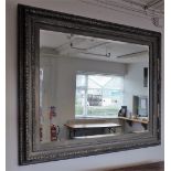 A large silver painted rectangular wall mirror, with egg and dart moulded frame and bevelled plate,
