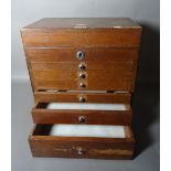 An early 20th century small mahogany collectors chest with lift top over six graduated drawers,