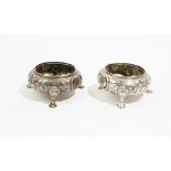 A pair of Victorian silver circular salts, each with floral and foliate embossed decoration,