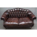 A Victorian style button upholstered brown leather hump back Chesterfield style sofa,