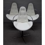 In the manner of Arne Jacobson; a set of three cream leather upholstered dining chairs,