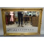 A modern gold painted rectangular wall mirror with bevelled glass, 108cm wide x 78cm high.