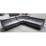 A modern black leather upholstered corner sofa, with ribbed design, 75cm high x 275cm x 275cm.