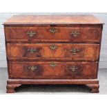 A George II feather banded walnut chest with four long graduated drawers, on ogee bracket feet,