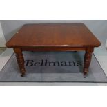 A late Victorian mahogany extending dining table, three extra leaves on reeded, turned supports,