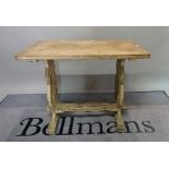An early 20th century oak side table, on trestle end supports united by a stretcher,