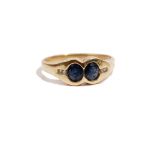 A gold, sapphire and diamond ring, mounted with two oval cut sapphires,