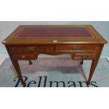 A late Victorian walnut four drawer writing desk, on tapering square supports,