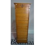 A mid-20th century oak floor standing filing cabinet, with tambour fronted sliding door,