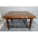 A Victorian mahogany extending dining table, on reeded tapering supports, with one extra leaf,