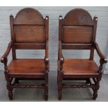 A pair of 17th century style oak panel back open armchairs on turned supports,