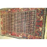 A Tehran rug, Persian, the dark indigo field with rows of botehs; a burgundy border of trees, birds,