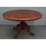 A Victorian figured walnut oval snap top loo table on four carved supports, 122cm wide x 71cm high.