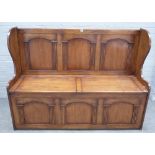 An 18th century style oak triple arch panel back box seat settle, 144cm wide x 107cm high.