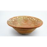 A large slip decorated terracotta bowl, 62cm diameter x 21cm high, together with a similar smaller,