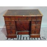 A 19th century mahogany writing desk with nine drawers about the knee on plinth base,