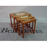 'TRAN', a mid-20th century teak Danish nest of three tables, with inset floral tiles,