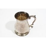 A late George II silver mug, of baluster form, with a scrolling handle, raised on a circular foot,