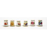 A group of six Royal Worcester thimbles, black printed marks, painted with flowers or fruit,