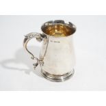 A Victorian silver baluster shaped mug, with a scrolling handle, raised on a circular foot,