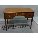 A George III mahogany kneehole writing desk, the three frieze drawers on tapering square supports,