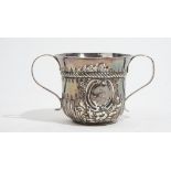 An early George III silver twin handled cup, with embossed fluted decoration below a reeded band,